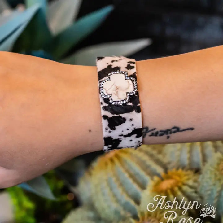 Wrist wearing a patterned bracelet with a blurred natural background