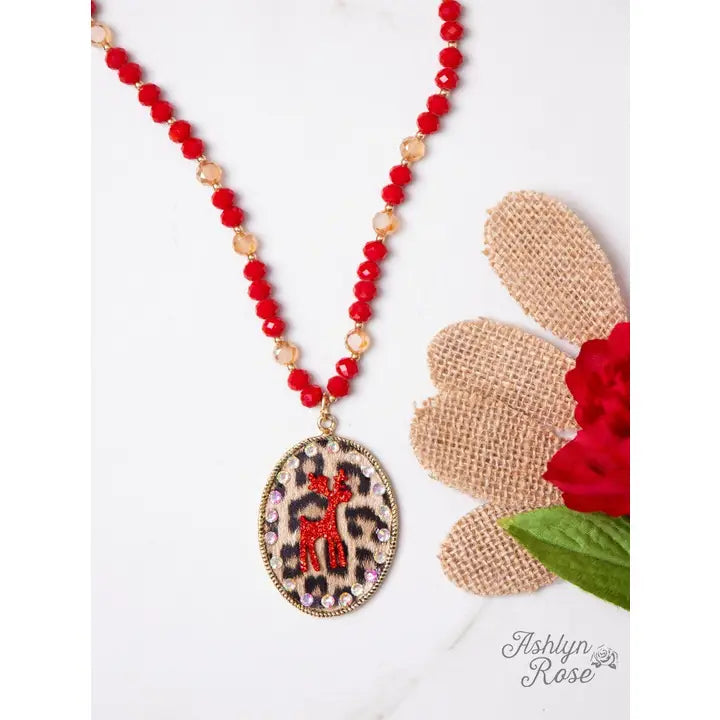 Necklace with red beads and a leopard print pendant on a white background