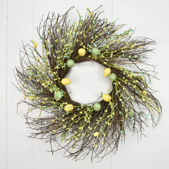 Decorative wreath with green and yellow eggs on a white background