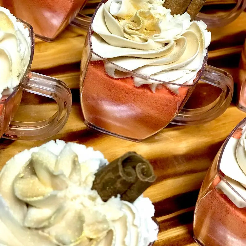 Small dessert cups with whipped cream on a wooden surface