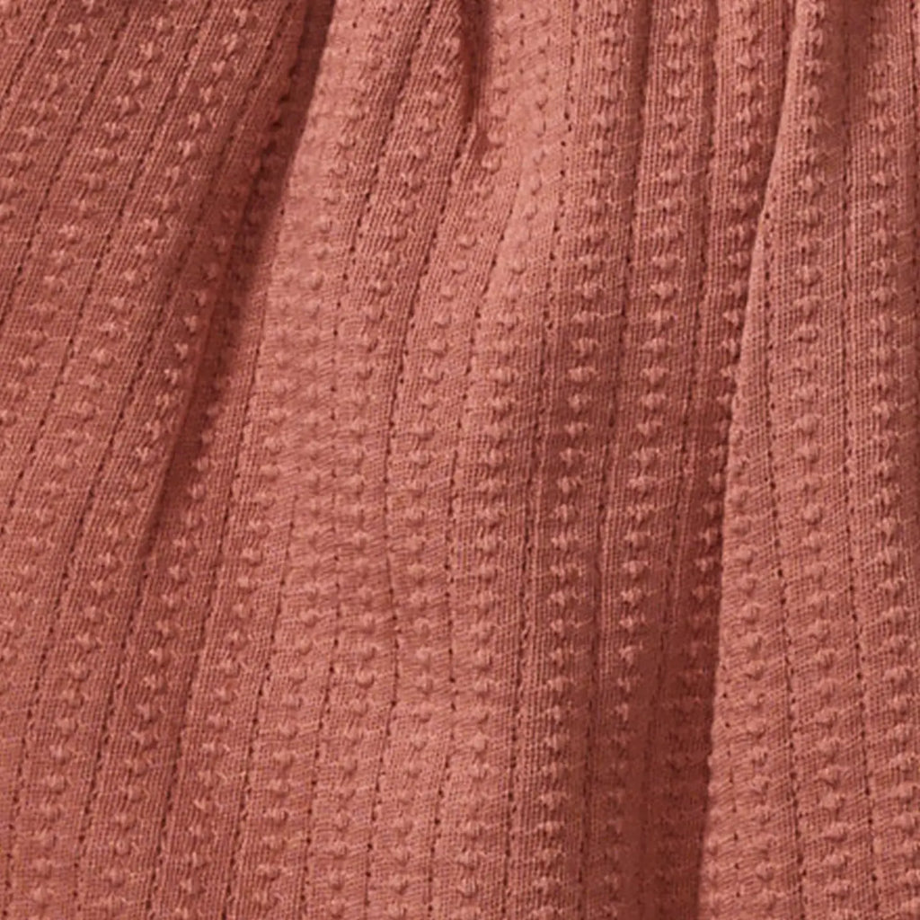 Close-up of a textured pink fabric with a subtle pattern