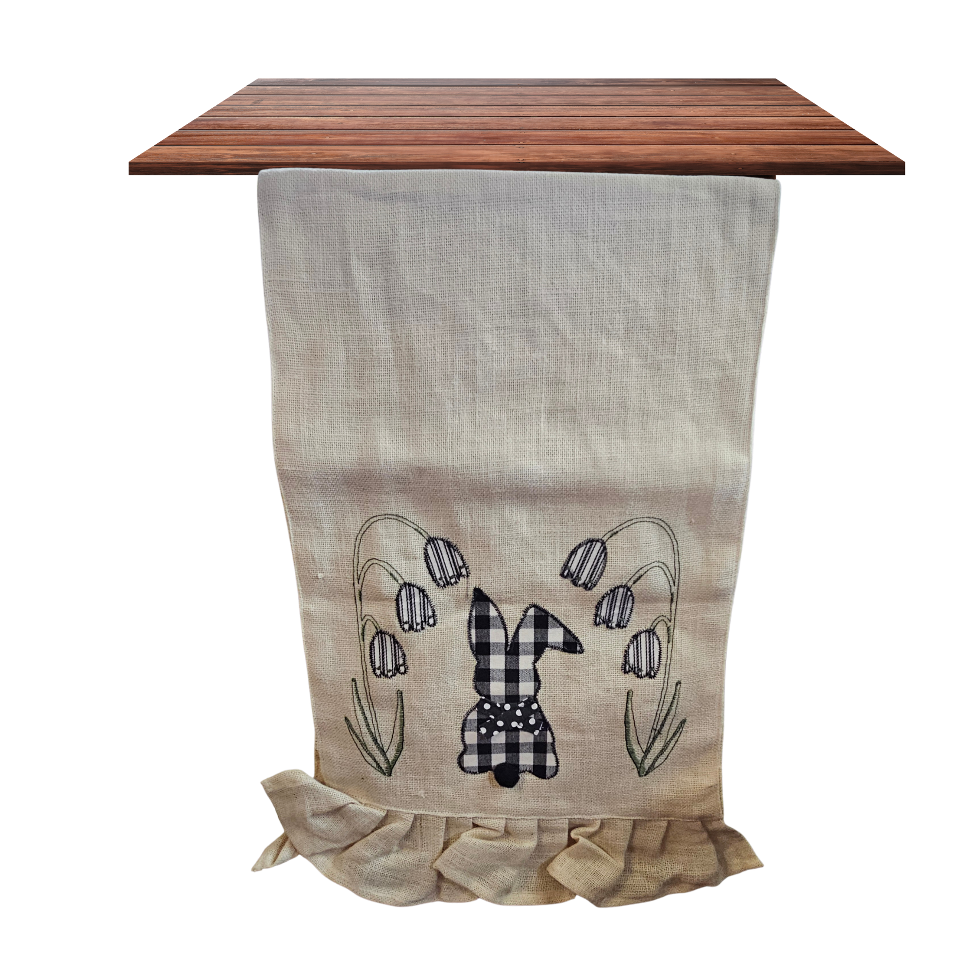 Decorative table runner with a checkered bunny design on a wooden surface