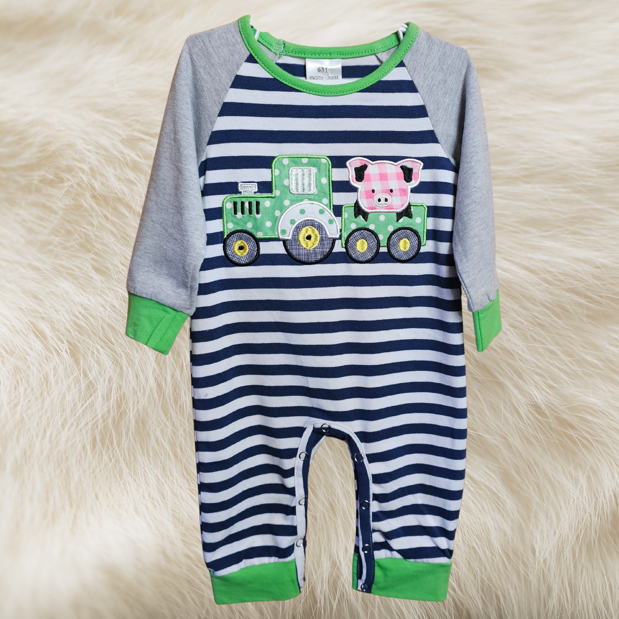 Striped baby romper with a cartoon design on a fluffy white surface