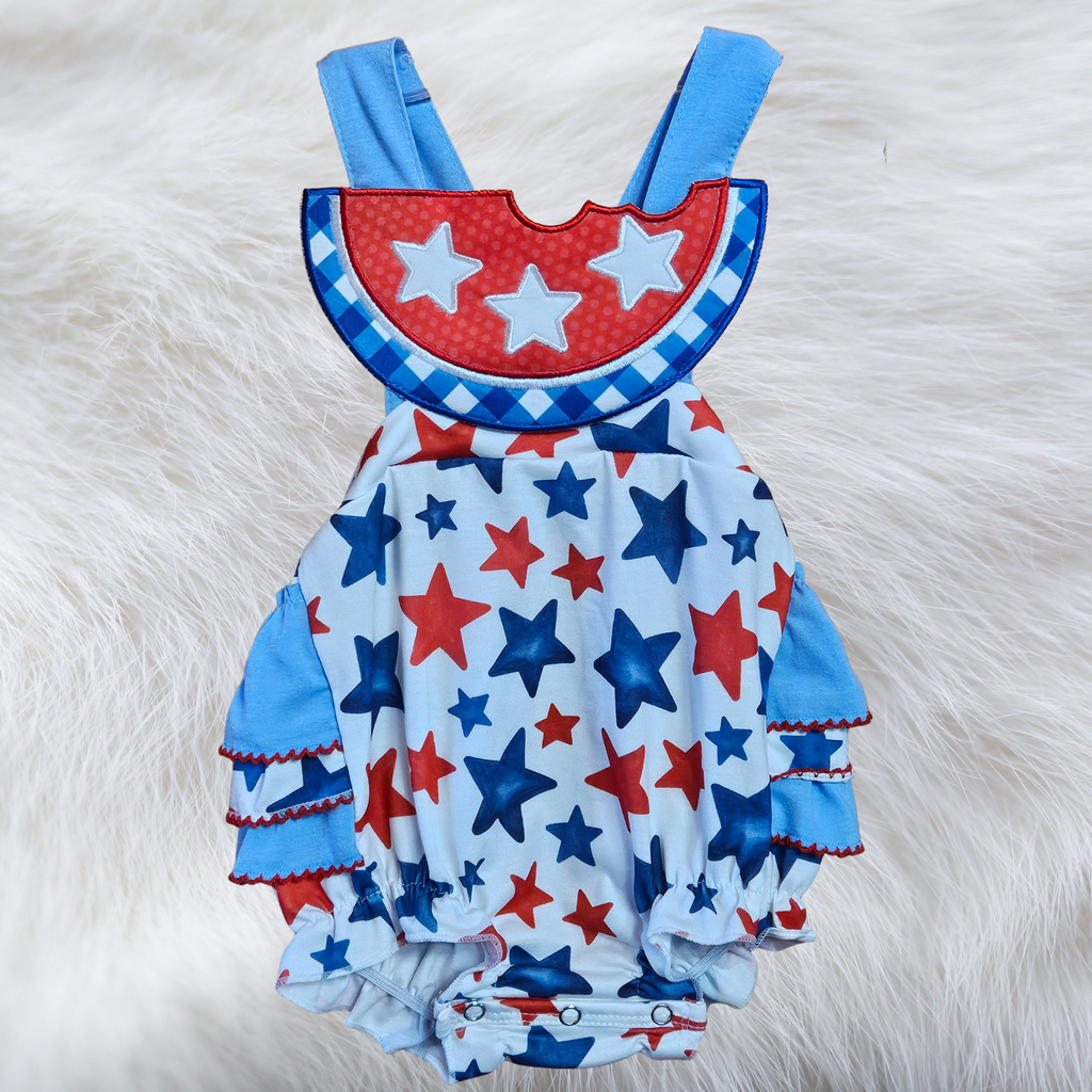 Children's romper with red, white, and blue star pattern on a fluffy white background