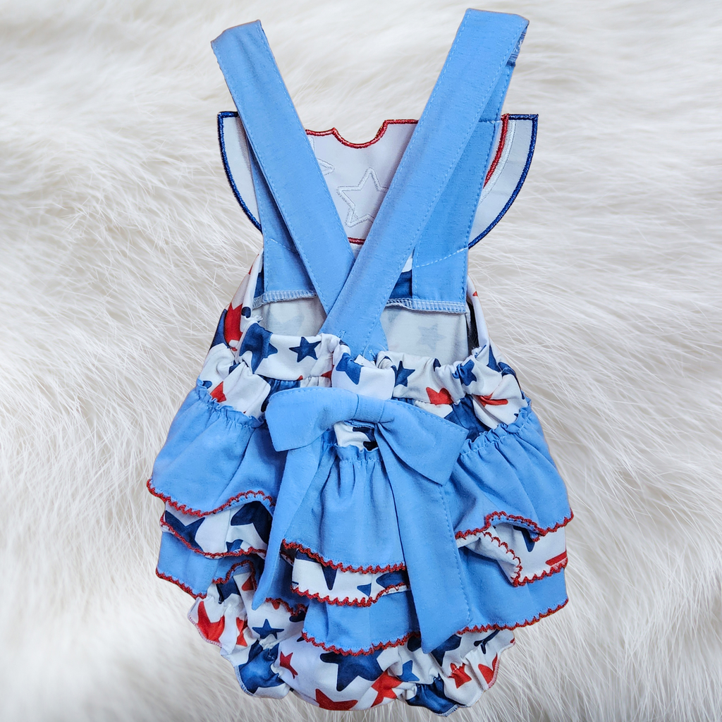 Children's blue romper with star pattern and suspenders on a white fur background