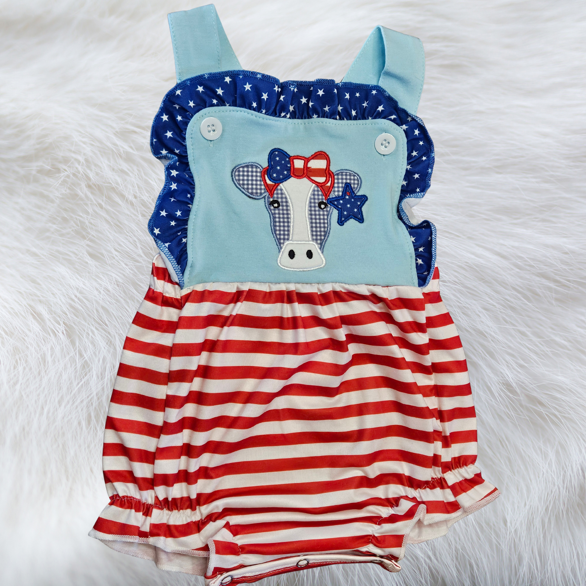 Children's romper with American flag design on a white fur background