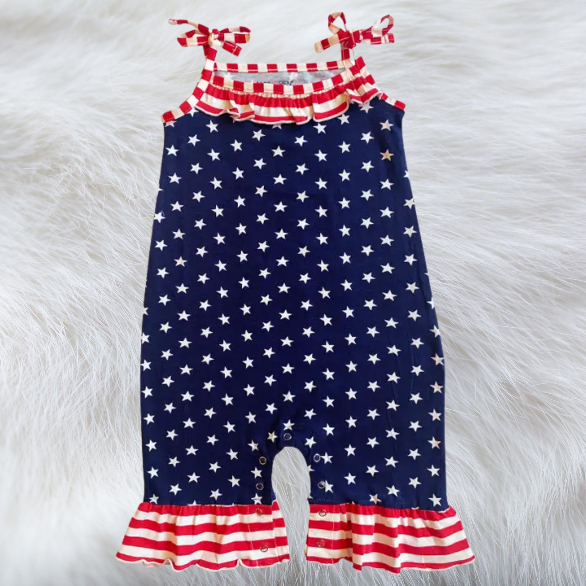 Children's romper with American flag pattern on a fluffy white background