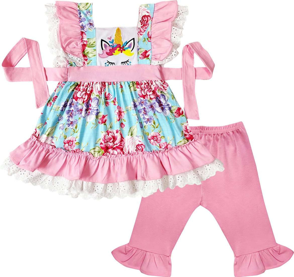 Children's outfit with floral dress and pink pants on a white background