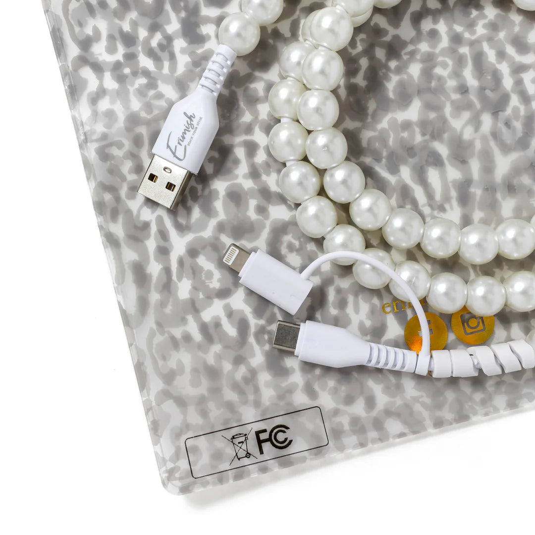 White USB cable with connectors on a gray patterned surface with pearls.