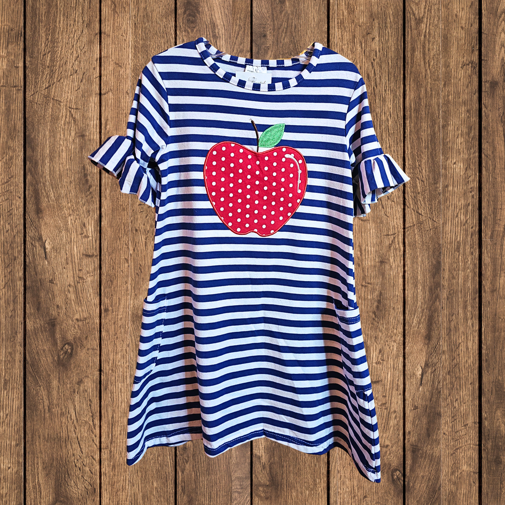 Blue and white striped dress with a red apple design on a wooden background