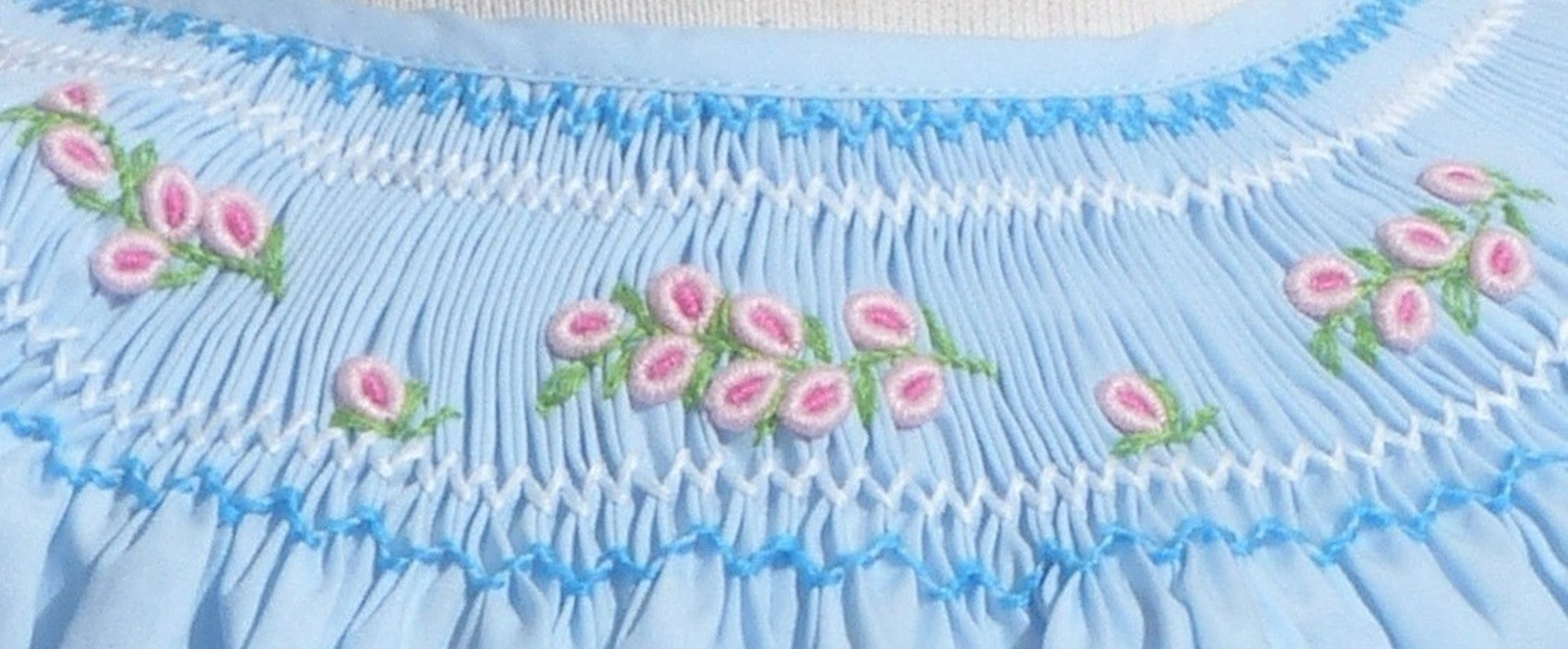 Light blue fabric with floral embroidery and ruffled edge