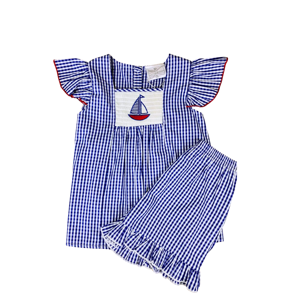Blue and white checkered outfit with a sailboat design on a white background