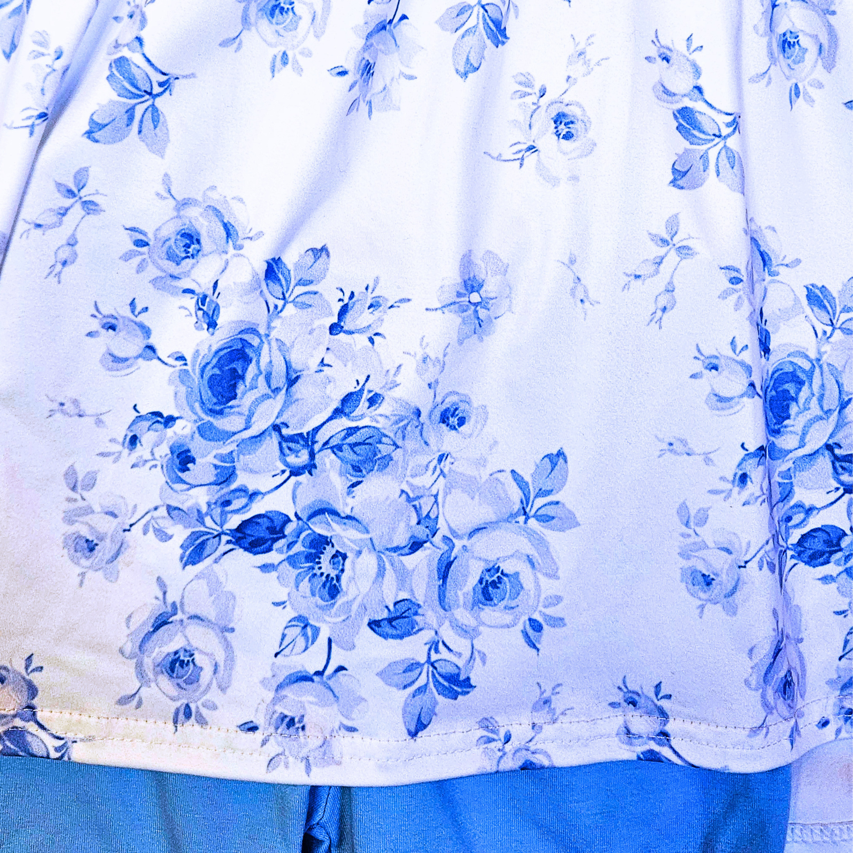 Close-up of a blue floral pattern on a white fabric background