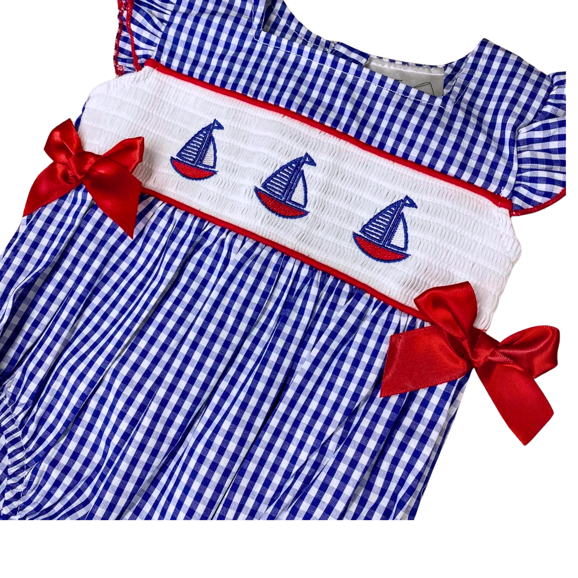 Blue and white checkered dress with red bows and sailboat design on a black background