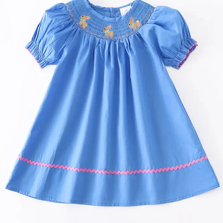 Blue dress with embroidered details on a white background