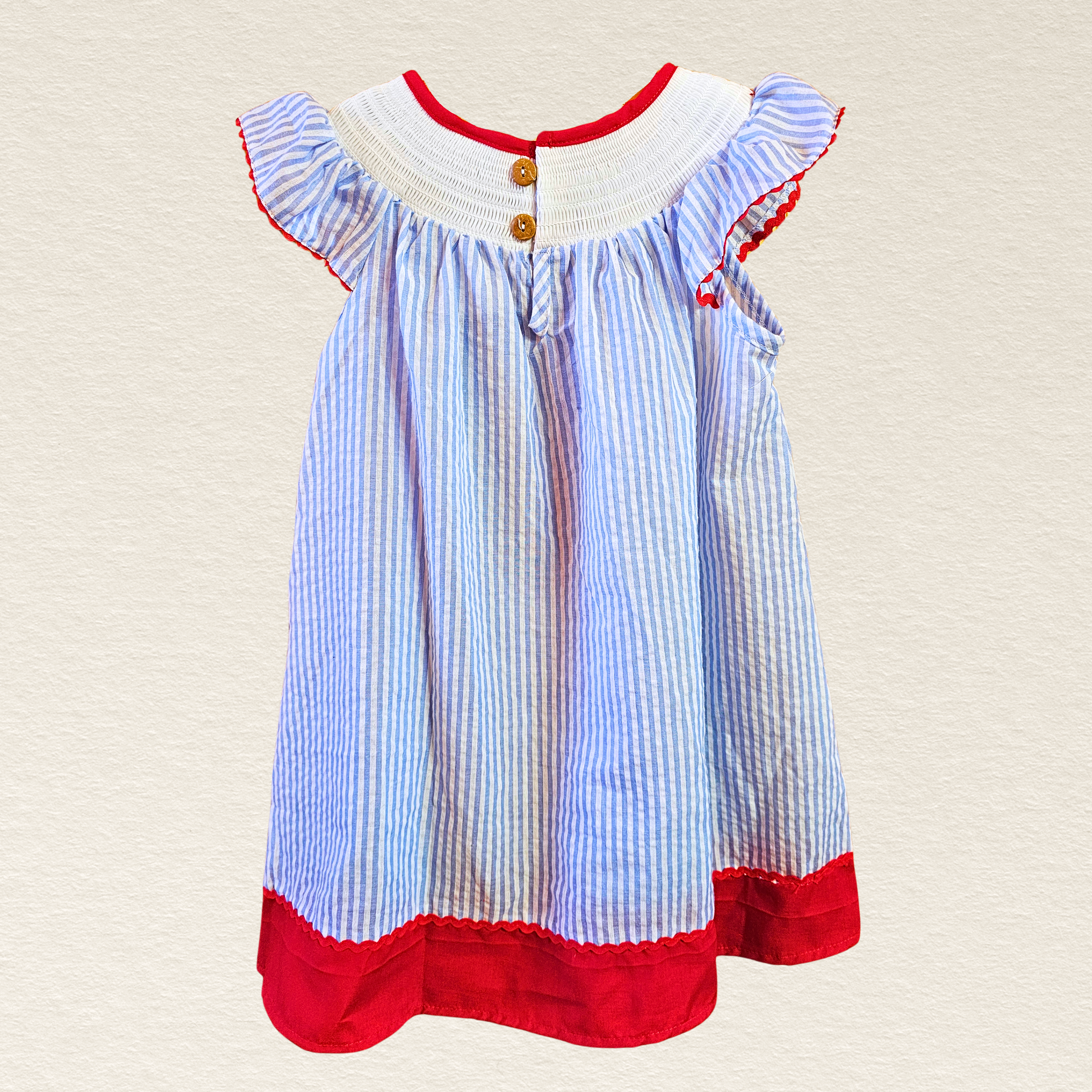 Blue and red striped dress with white trim on a beige background