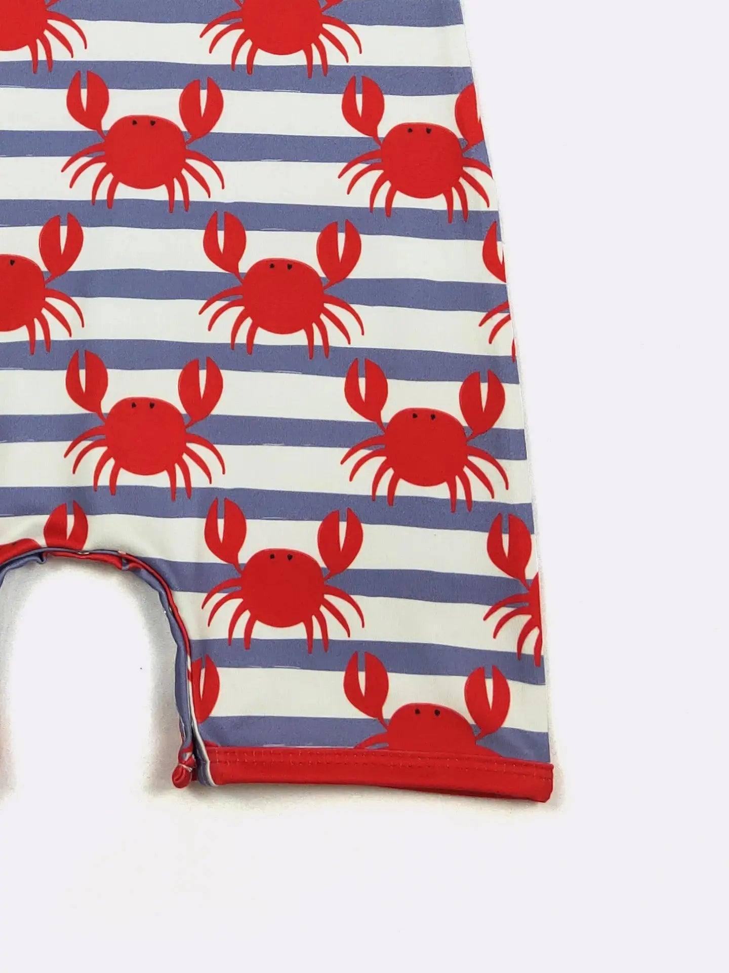 Folded fabric with red crab pattern on blue and white striped background