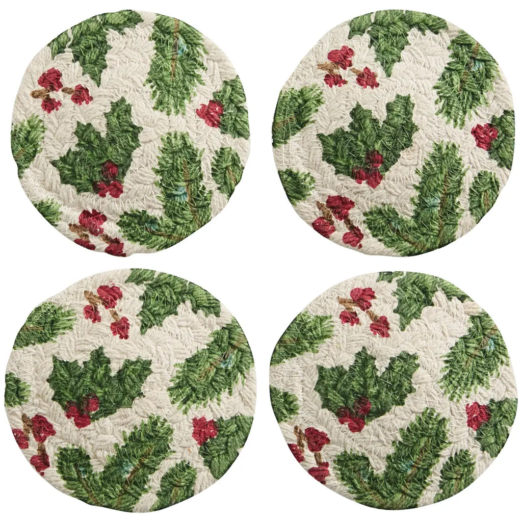 Four round coasters with holly leaf and berry pattern on a white background