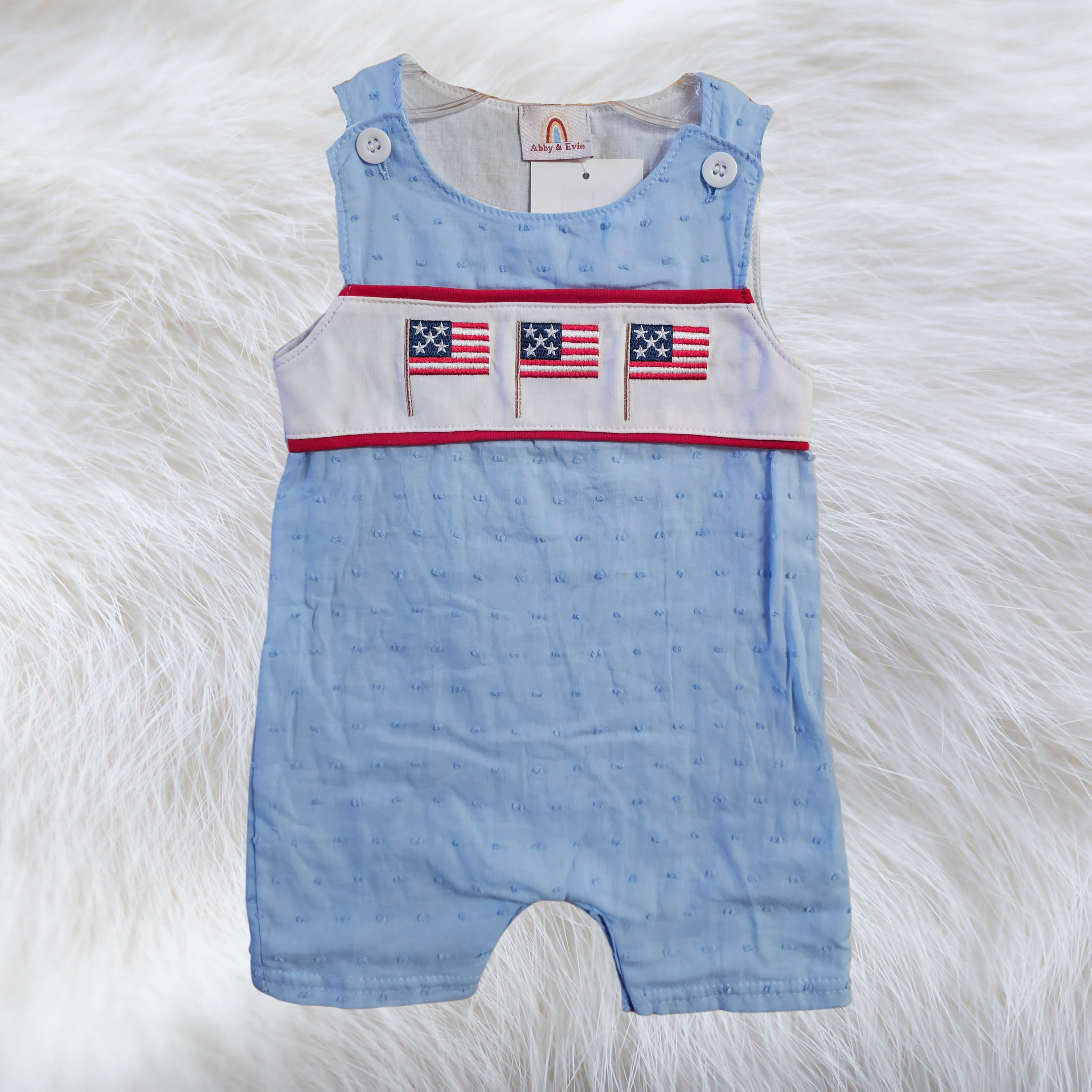 Light blue jon jon with three embroidered American flags on a fabric on a fuzzy white background