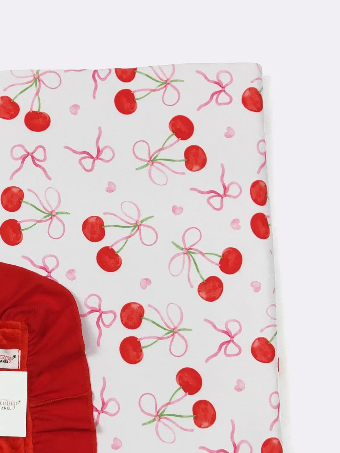 Red fabric with cherry and bow pattern on a white background
