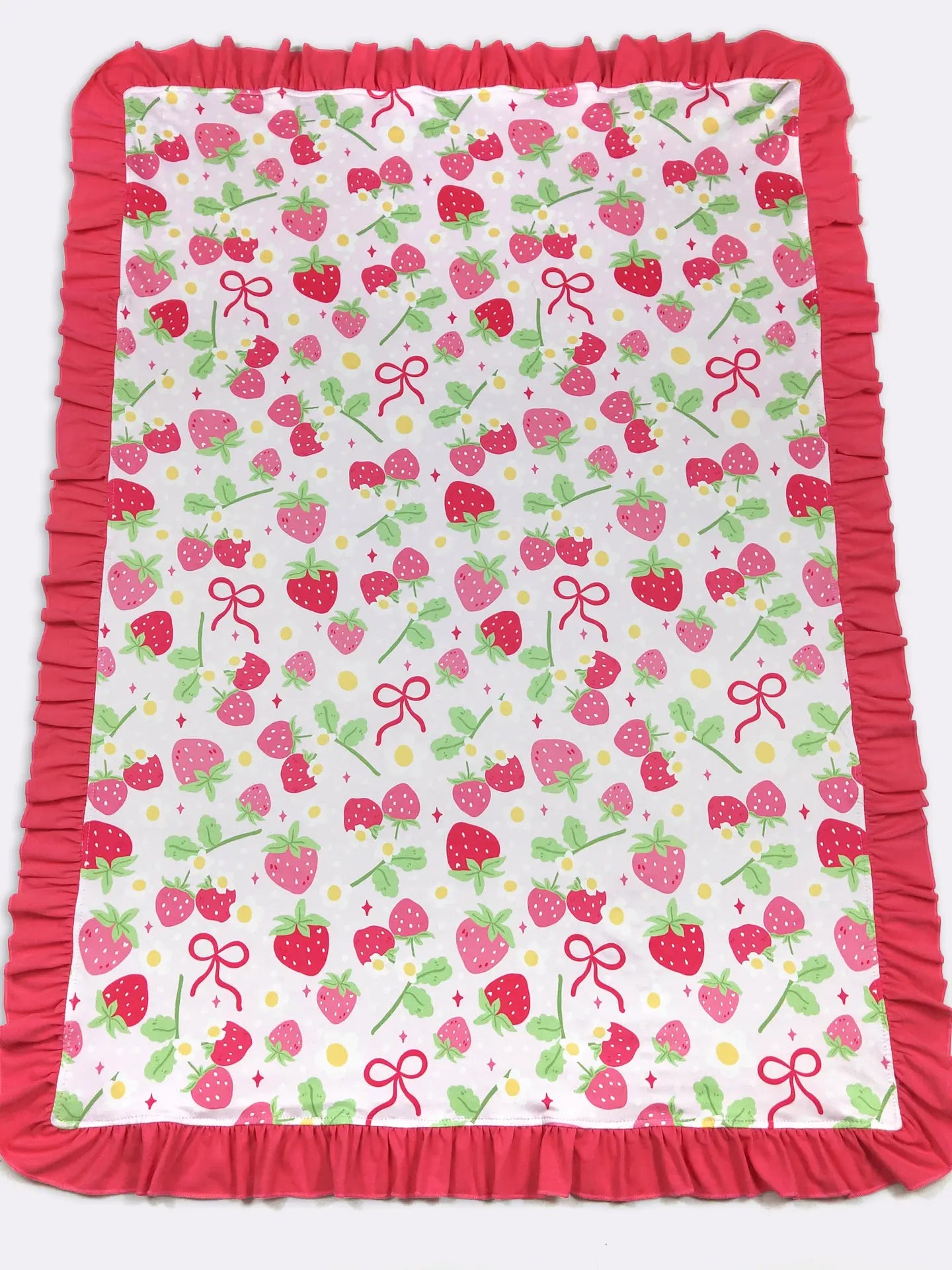Baby blanket with strawberry and bow pattern on a white background