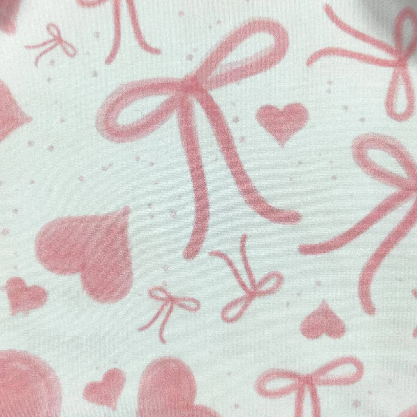 Pattern of pink hearts and bows on a white background