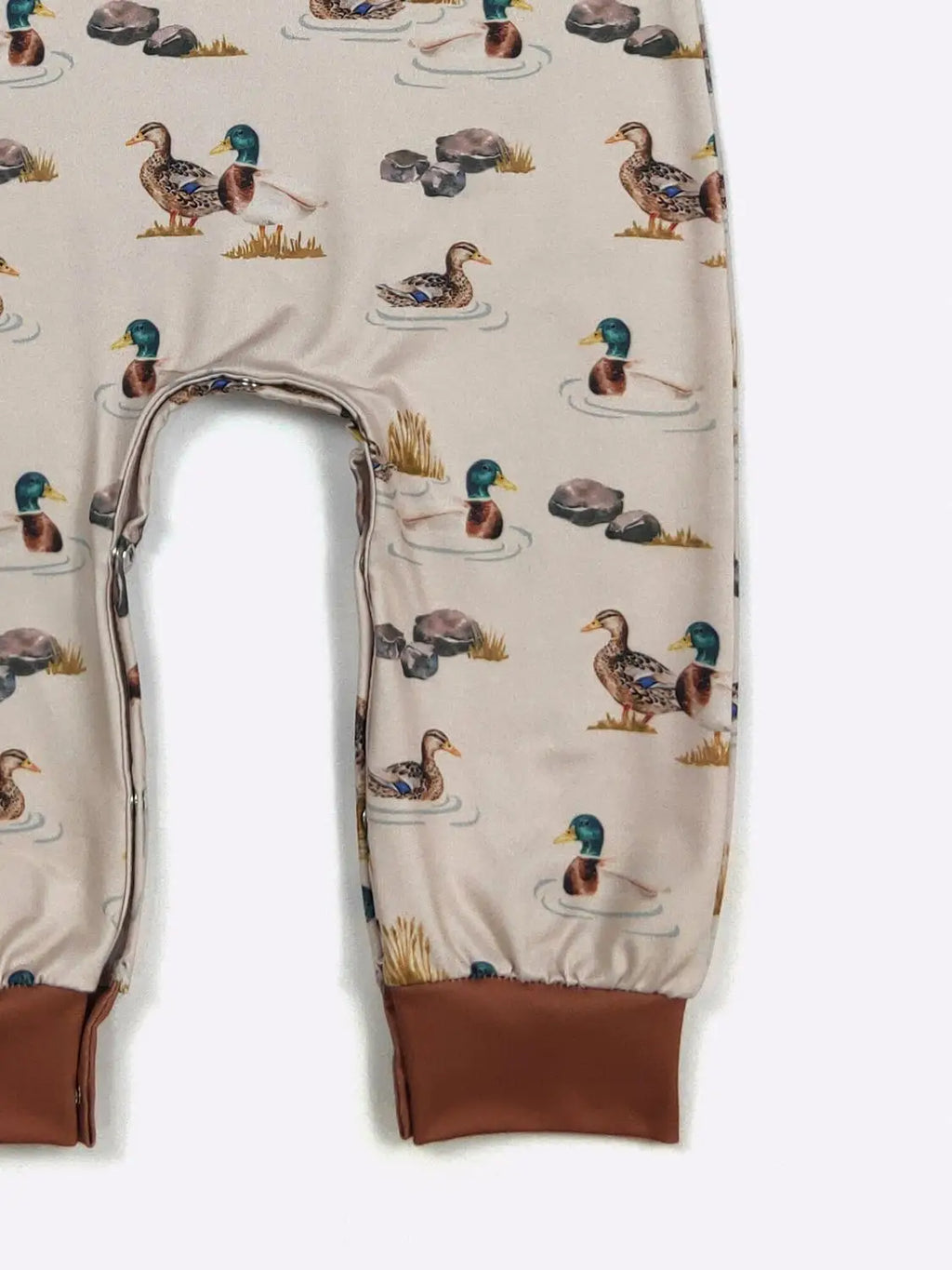 Baby leggings with duck pattern on a beige background