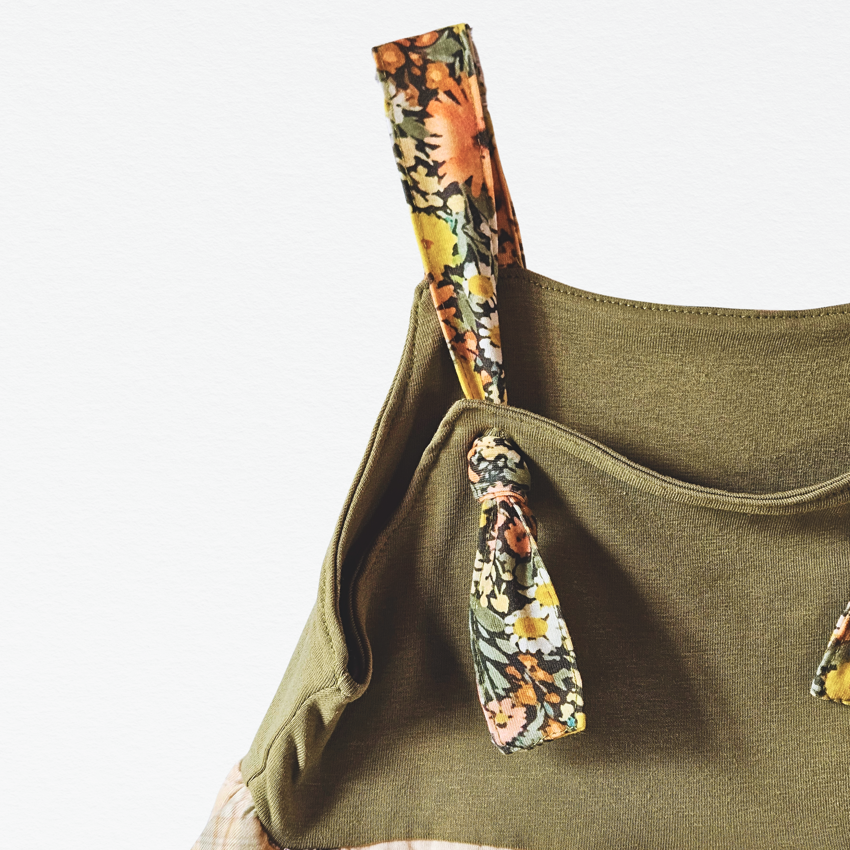 Green dress with floral-patterned handle on a white background
