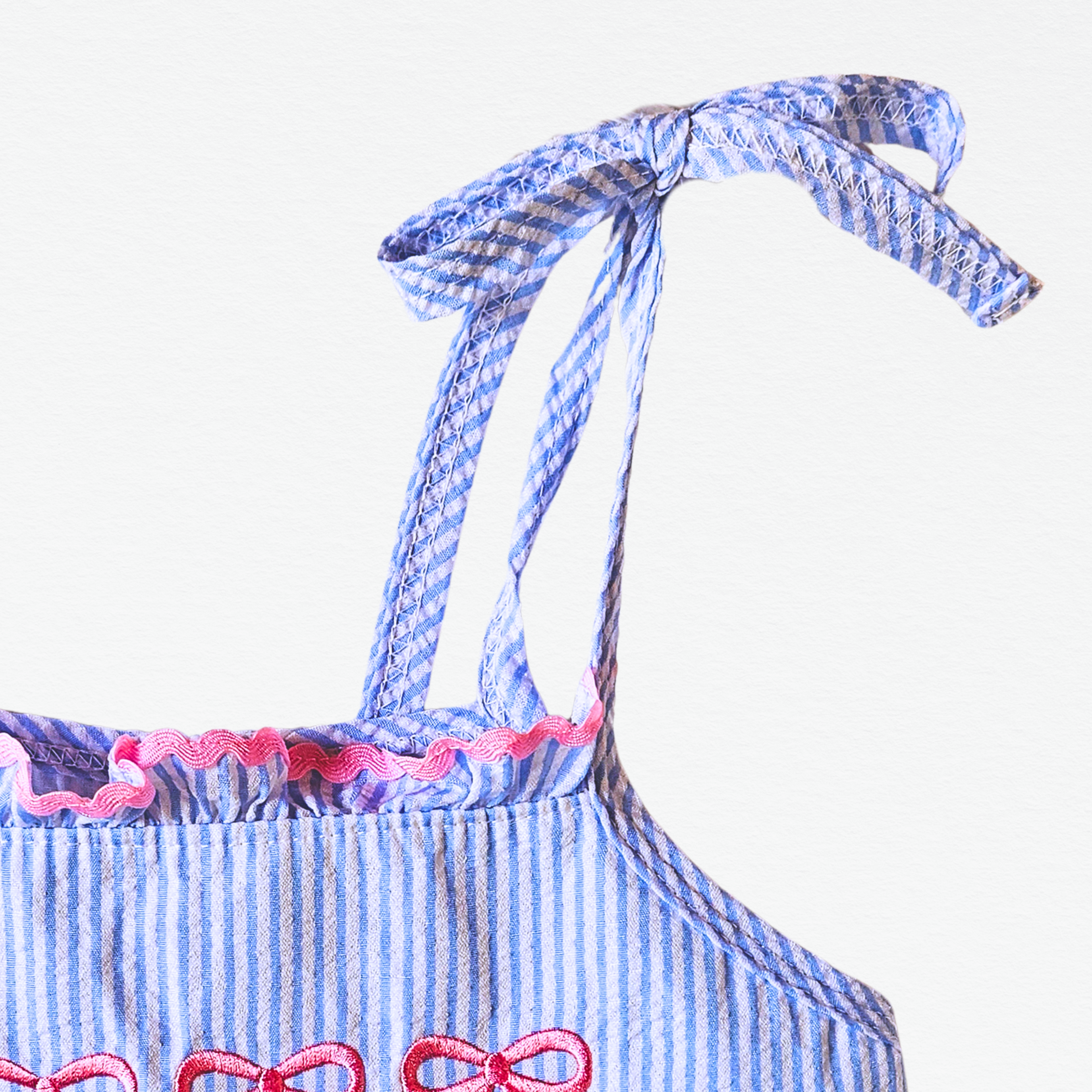 Blue and white striped dress with pink accents on a white background