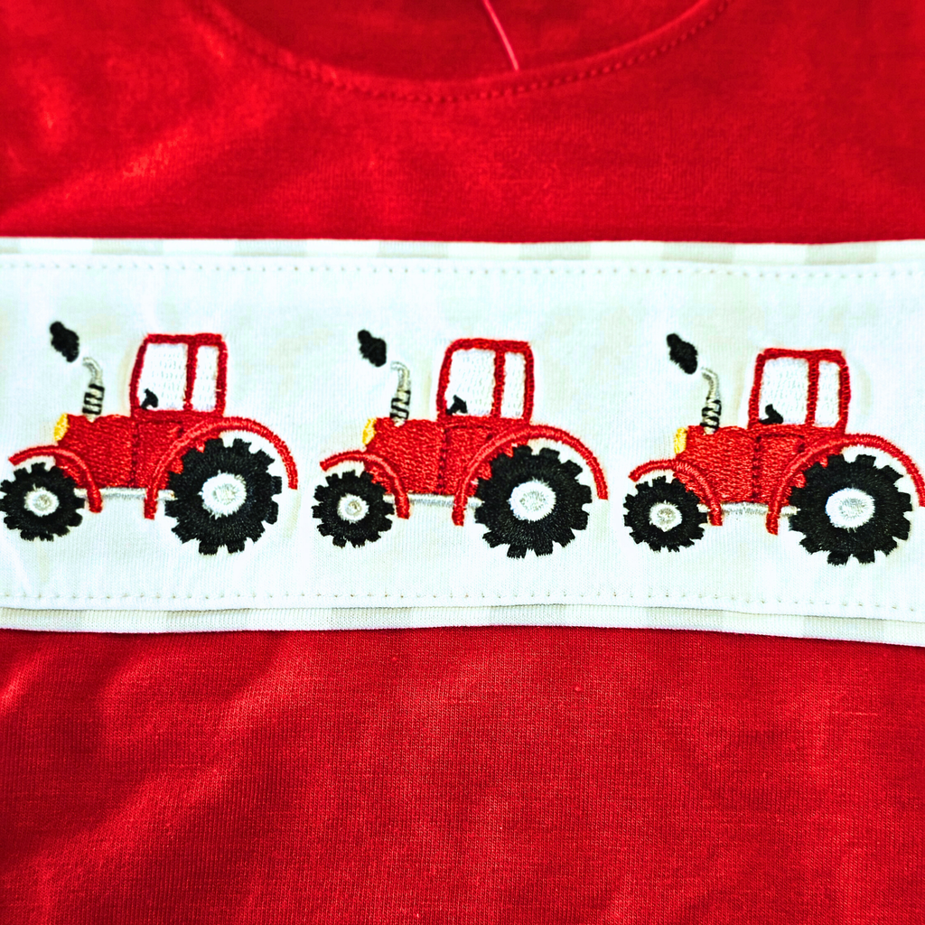Red shirt with embroidered tractors on a white stripe