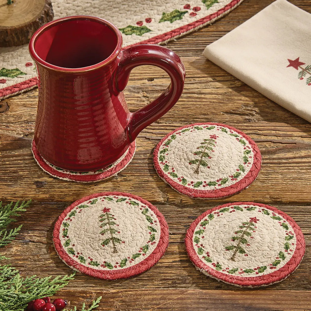 Red mug on a wooden surface with Christmas-themed coasters
