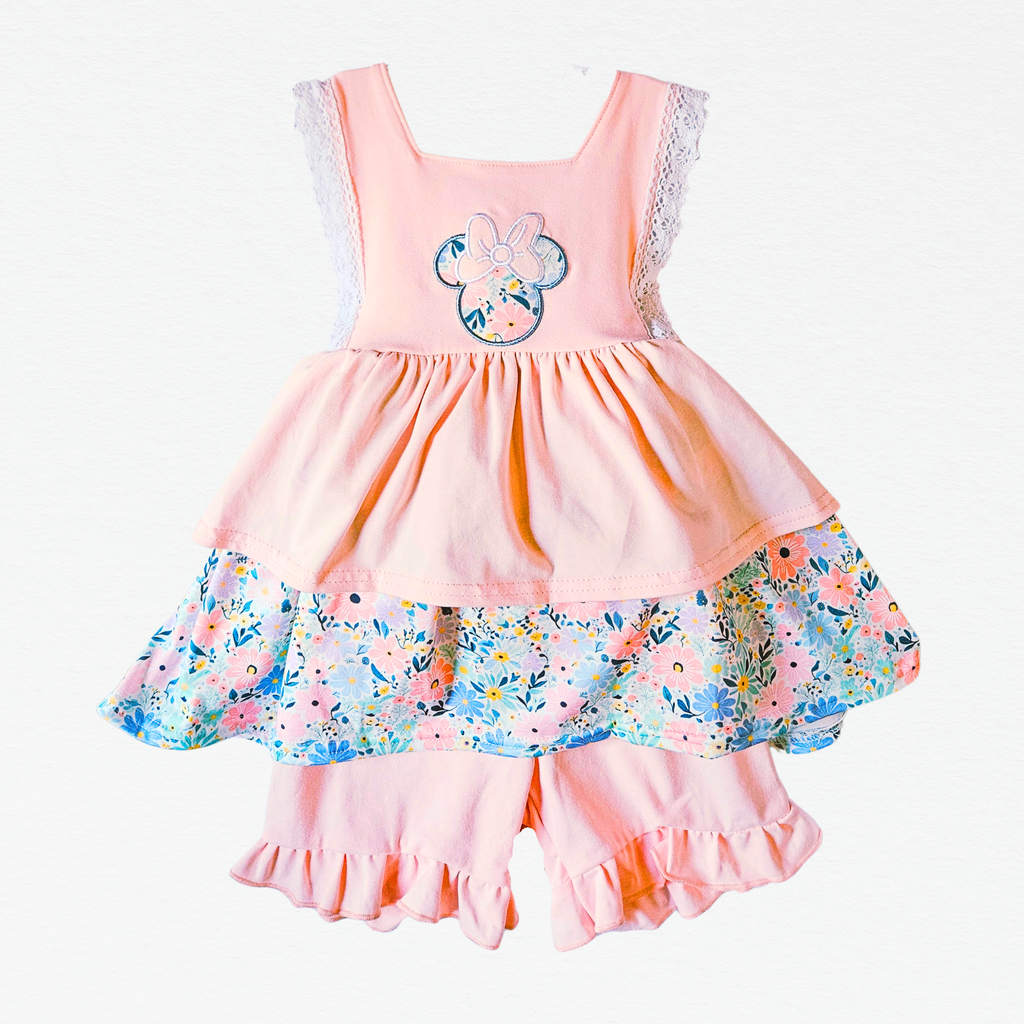 Pink shorts set with floral skirt and character design on a white background
