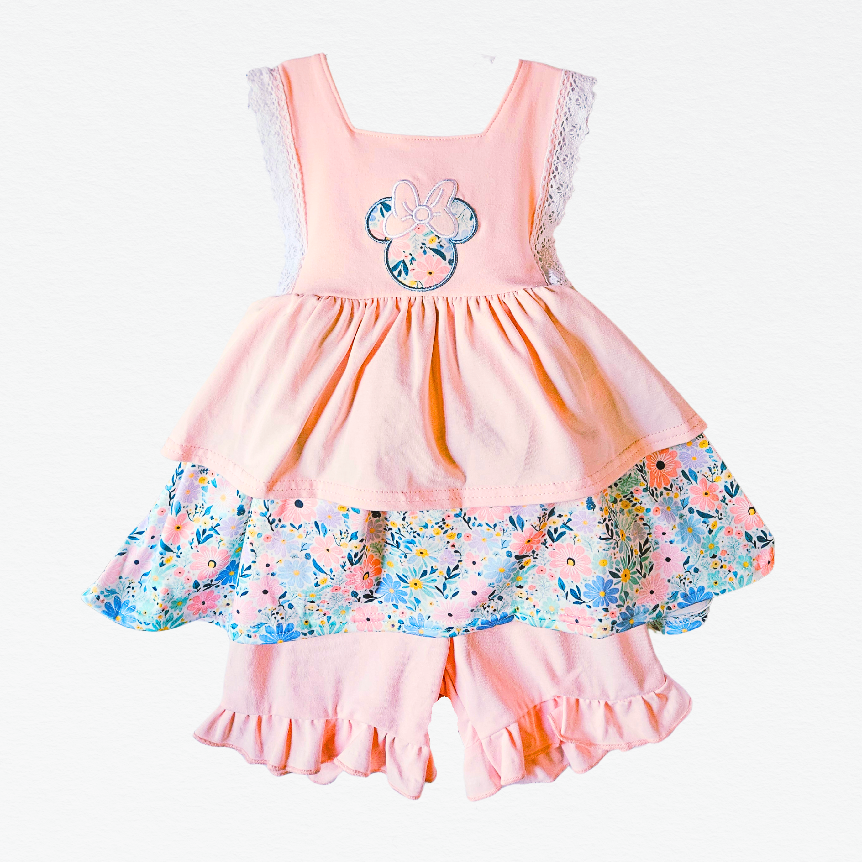 Pink shorts set with floral skirt and character design on a white background