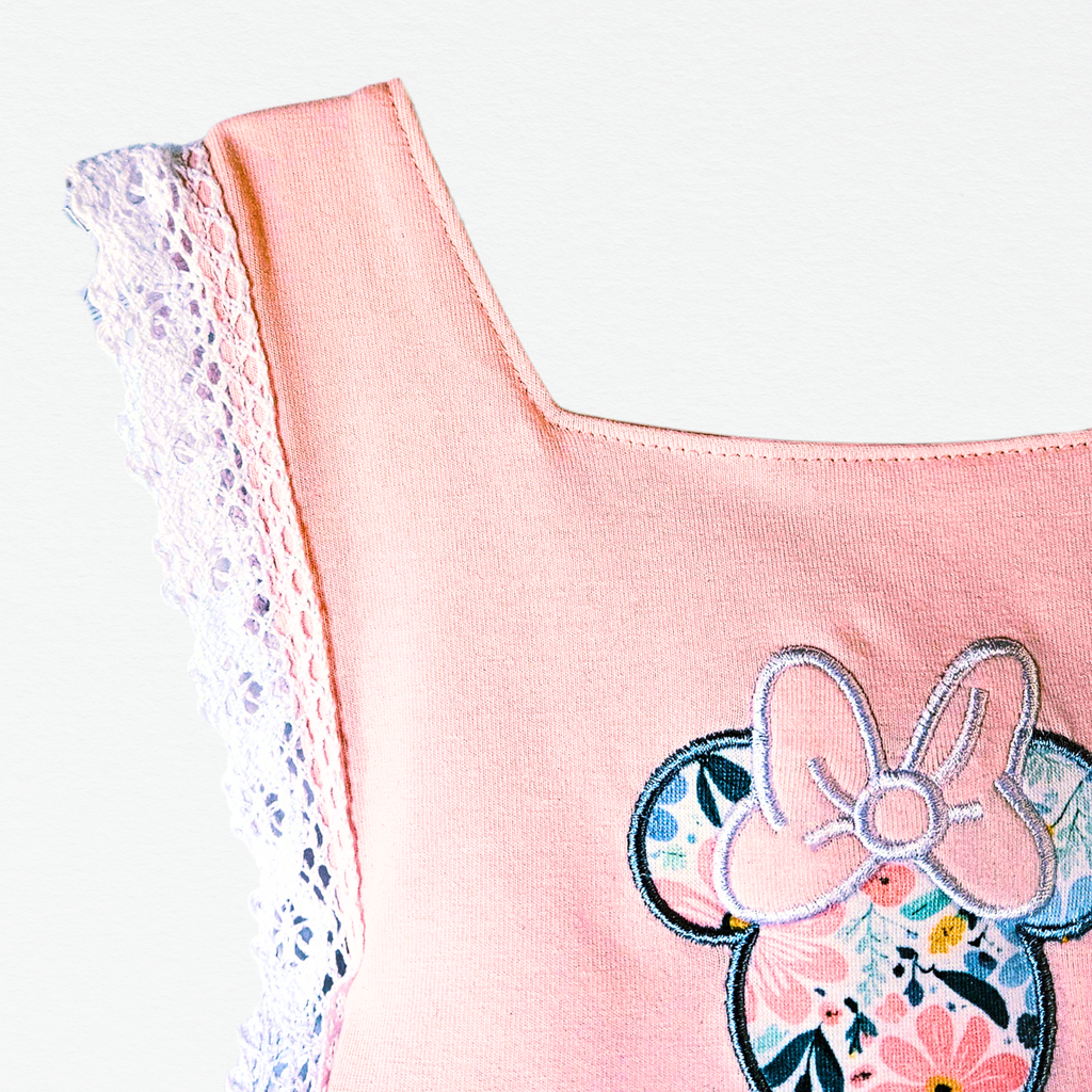 Pink top with floral and bow design on a white background