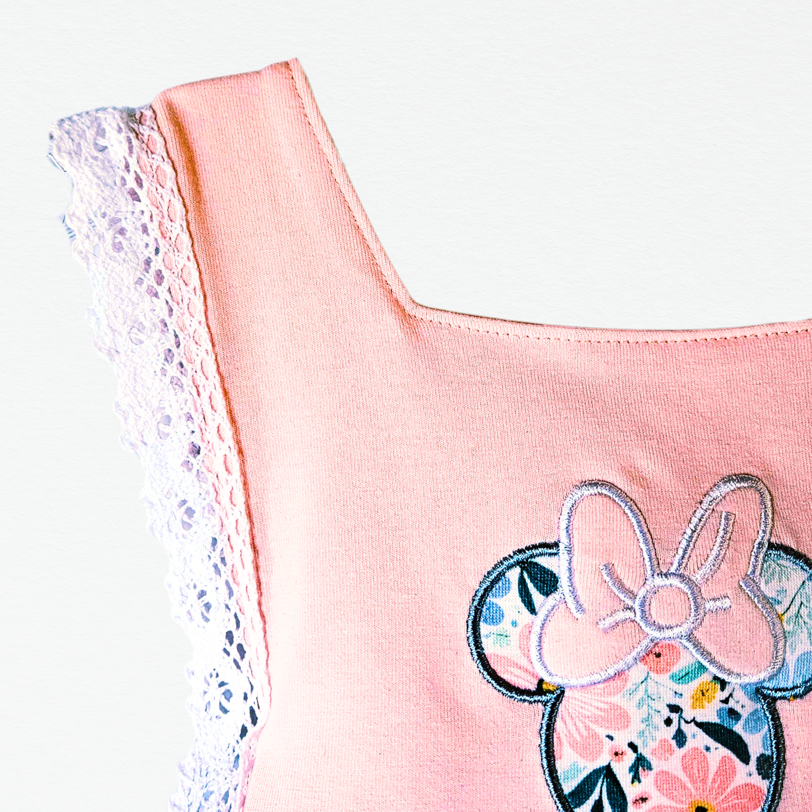 Pink top with floral and bow design on a white background