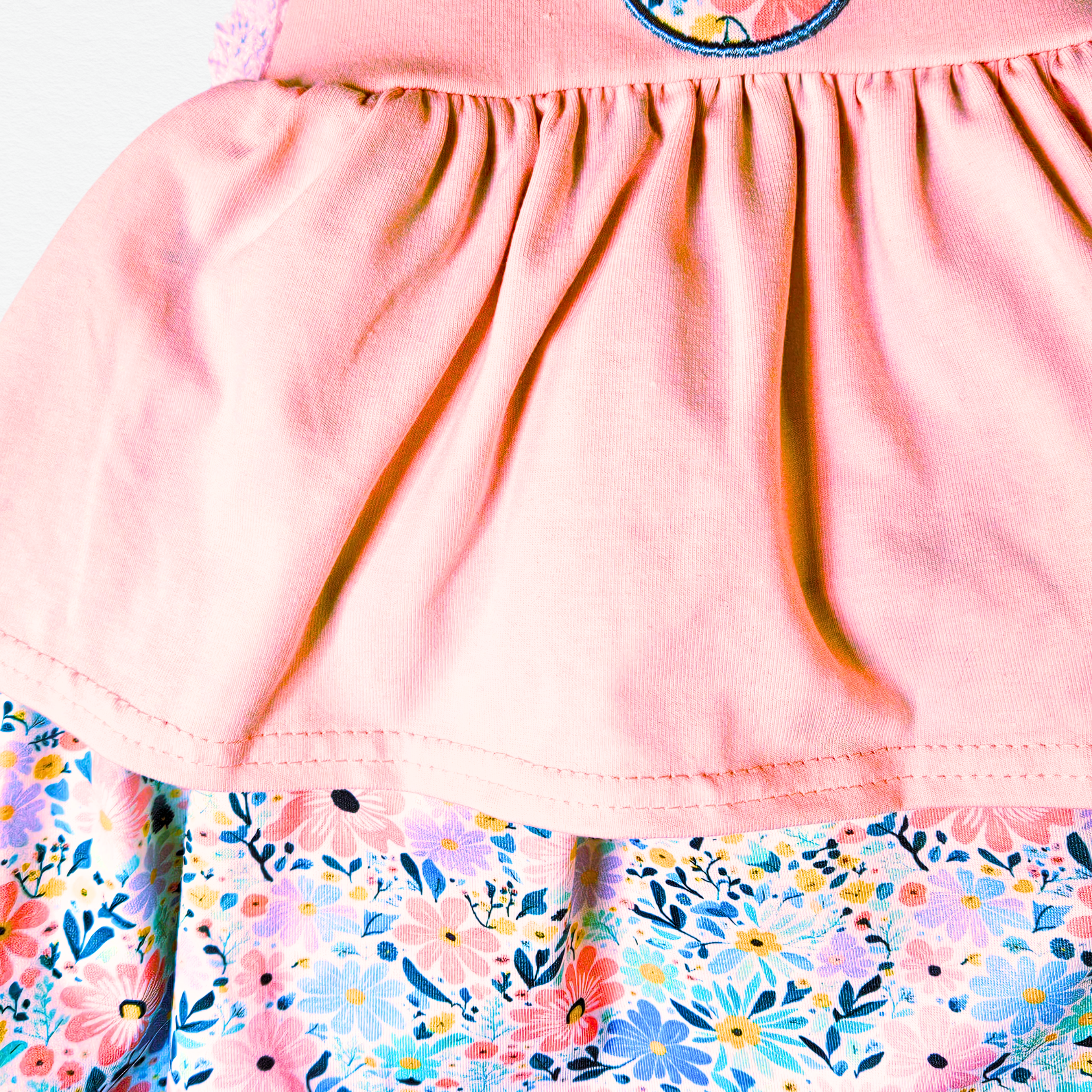 Close-up of a pink top with floral hem and neckline