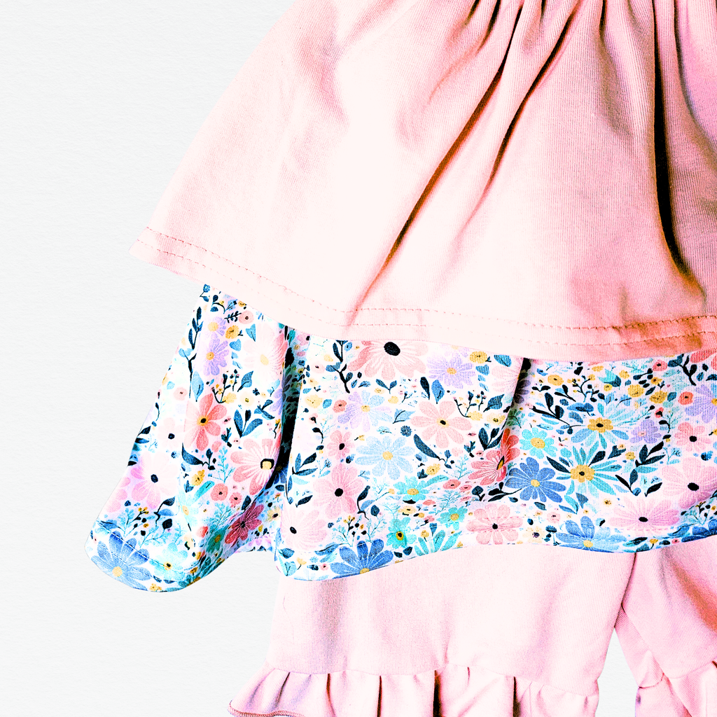 Pink dress with floral top and shorts on a white background