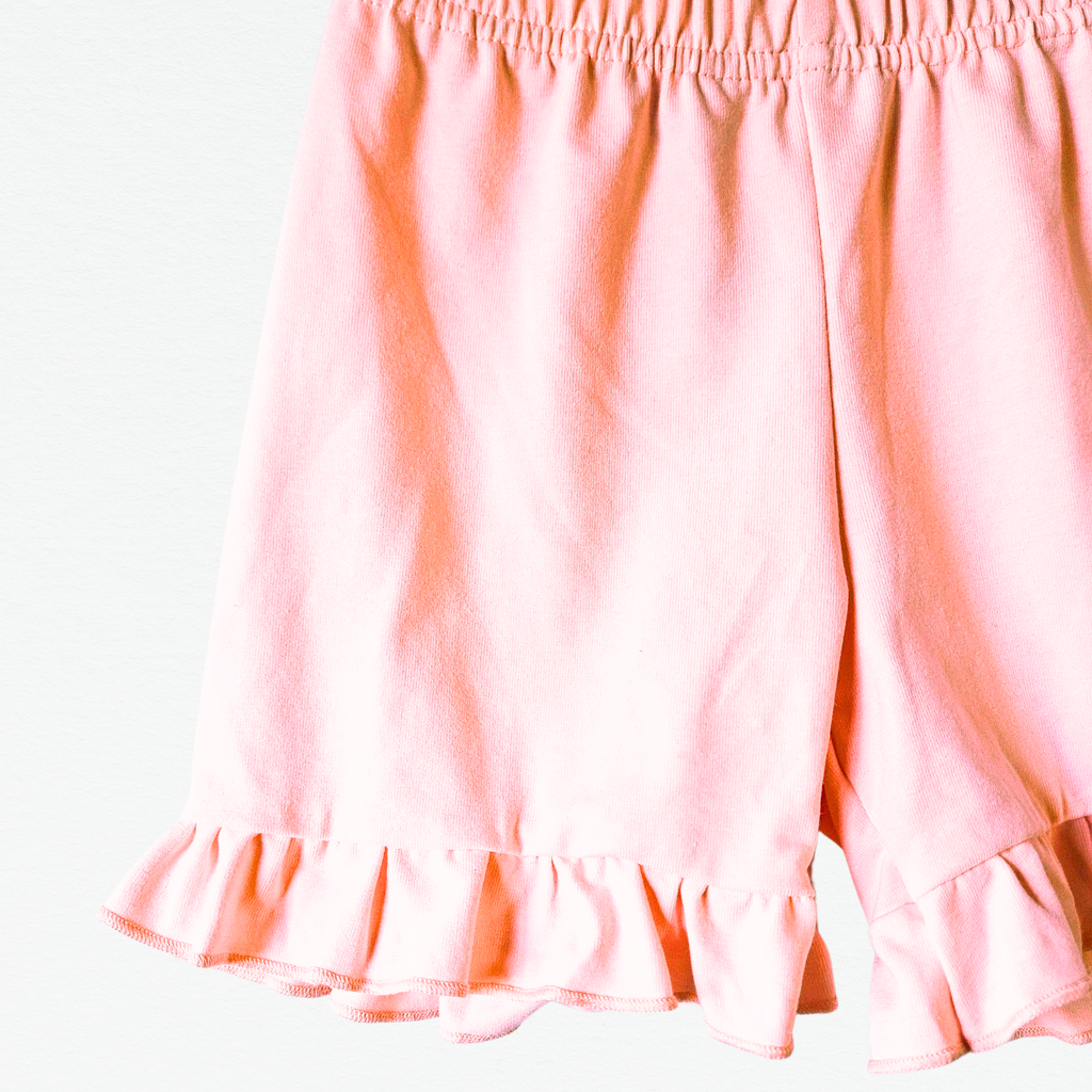 Pink shorts with ruffled hem on a white background
