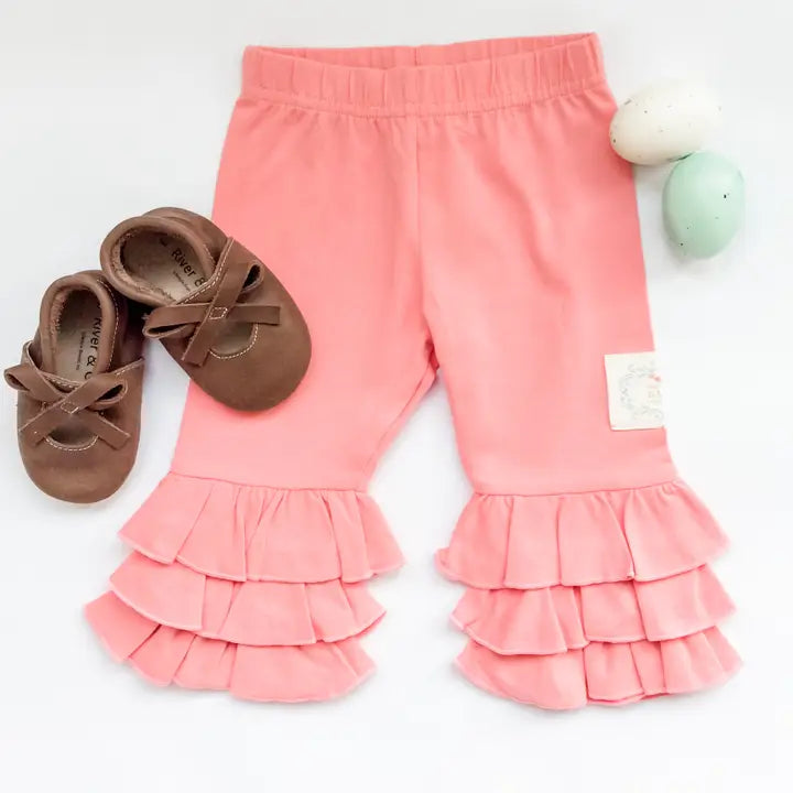 Pink ruffled pants with brown shoes on a white background