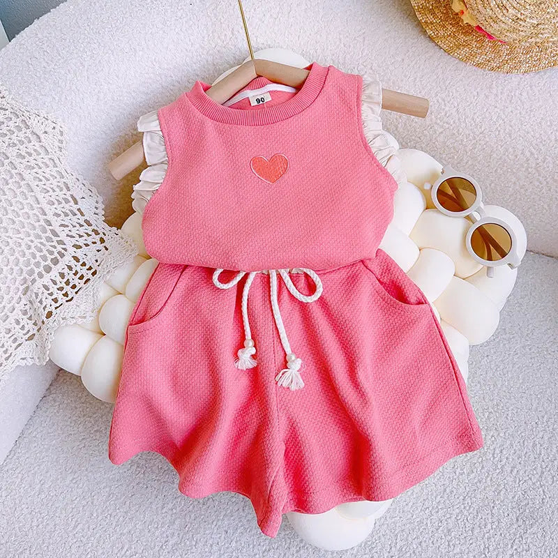 Pink short set with a heart design on a white surface