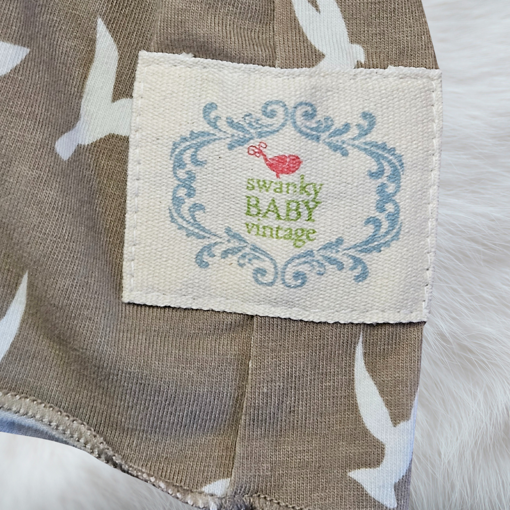 Fabric tag with 'swanky BABY vintage' text on a textured fabric background