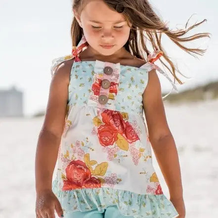 Young girl wearing a floral dress on a beach