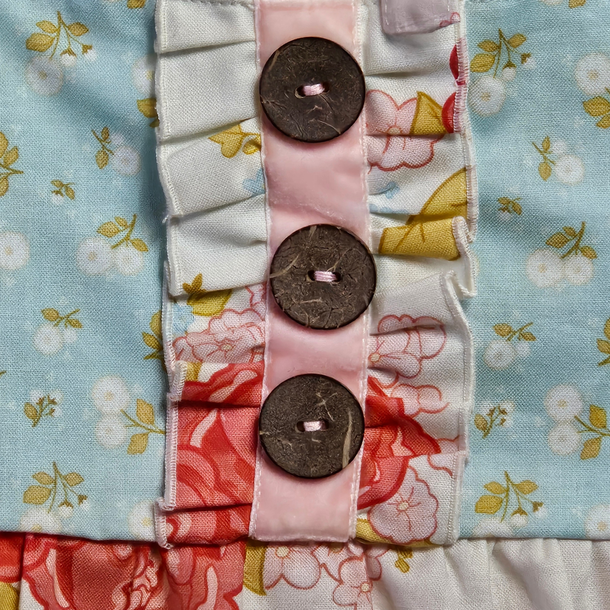Decorative fabric strip with buttons on a floral background