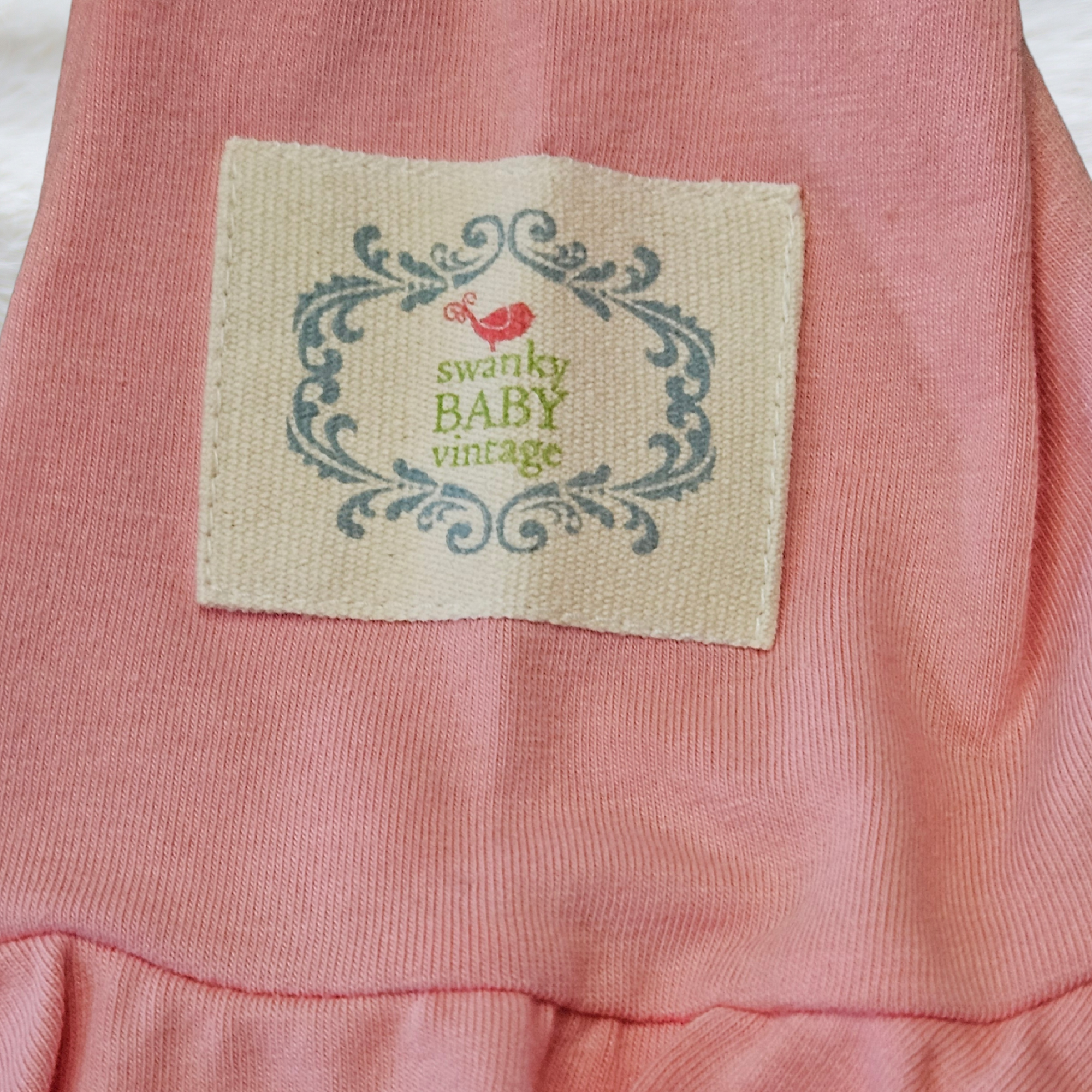 Pink fabric with a 'swanky BABY vintage' label