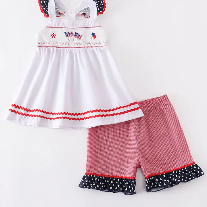 Children's outfit with white top and red shorts on a white background