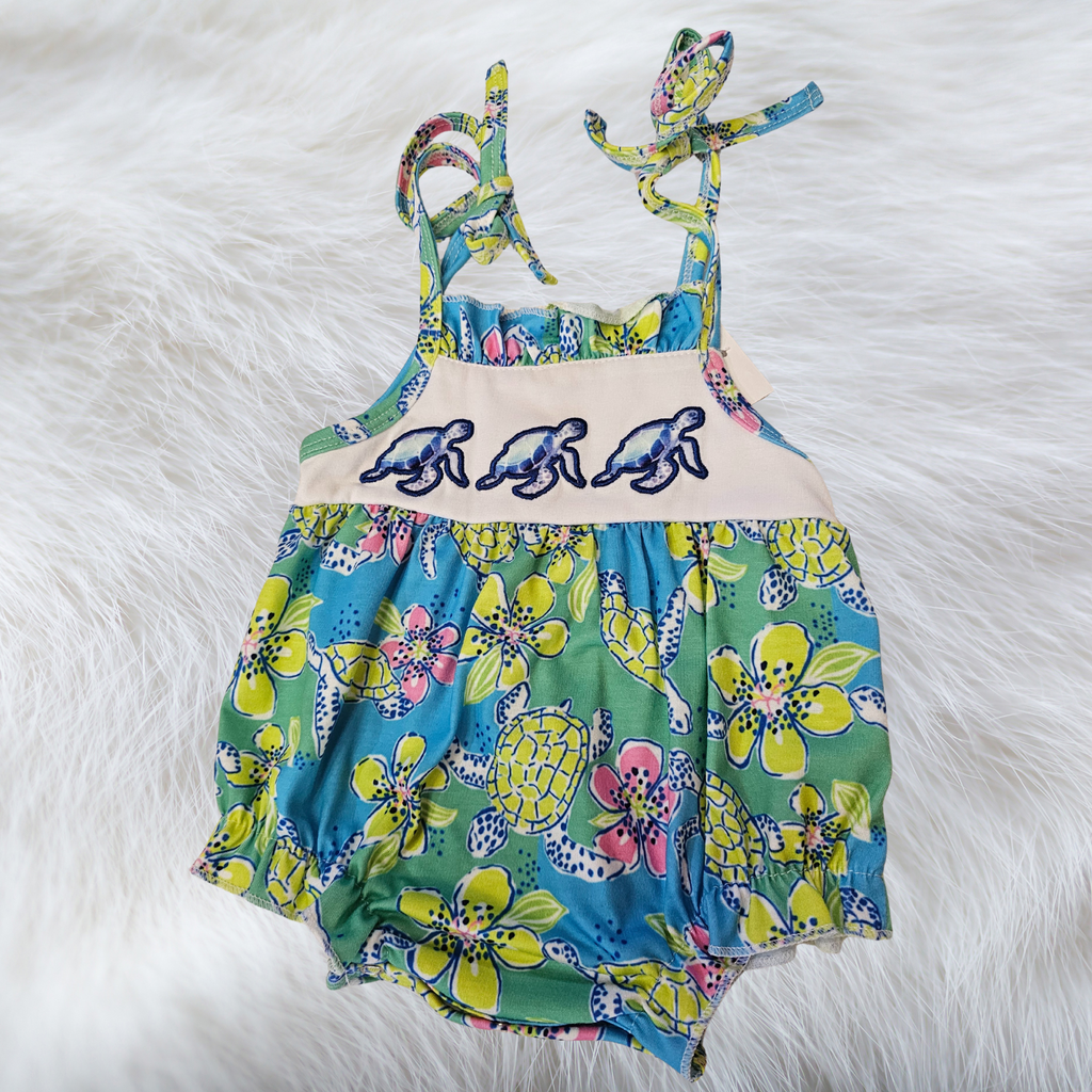 Colorful children's swimsuit with turtle design on a white fur background