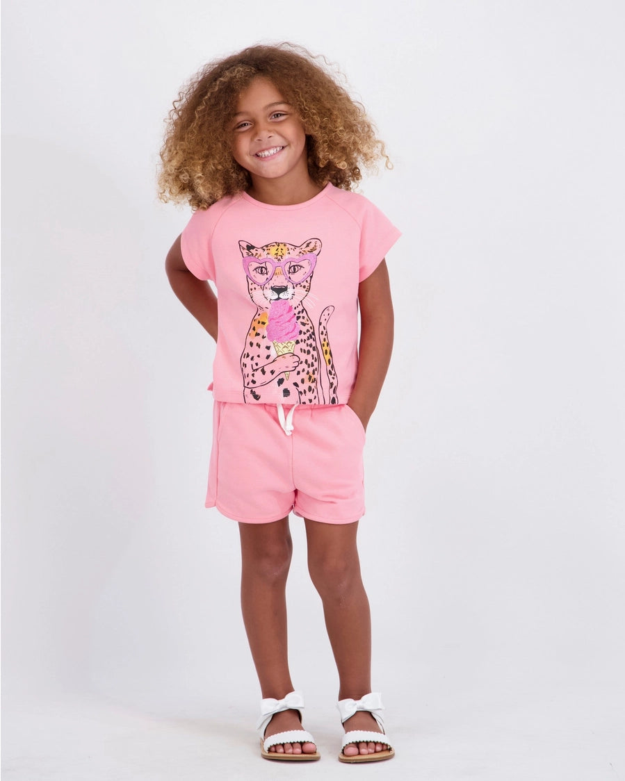 Child wearing a pink outfit with a leopard graphic on a white background