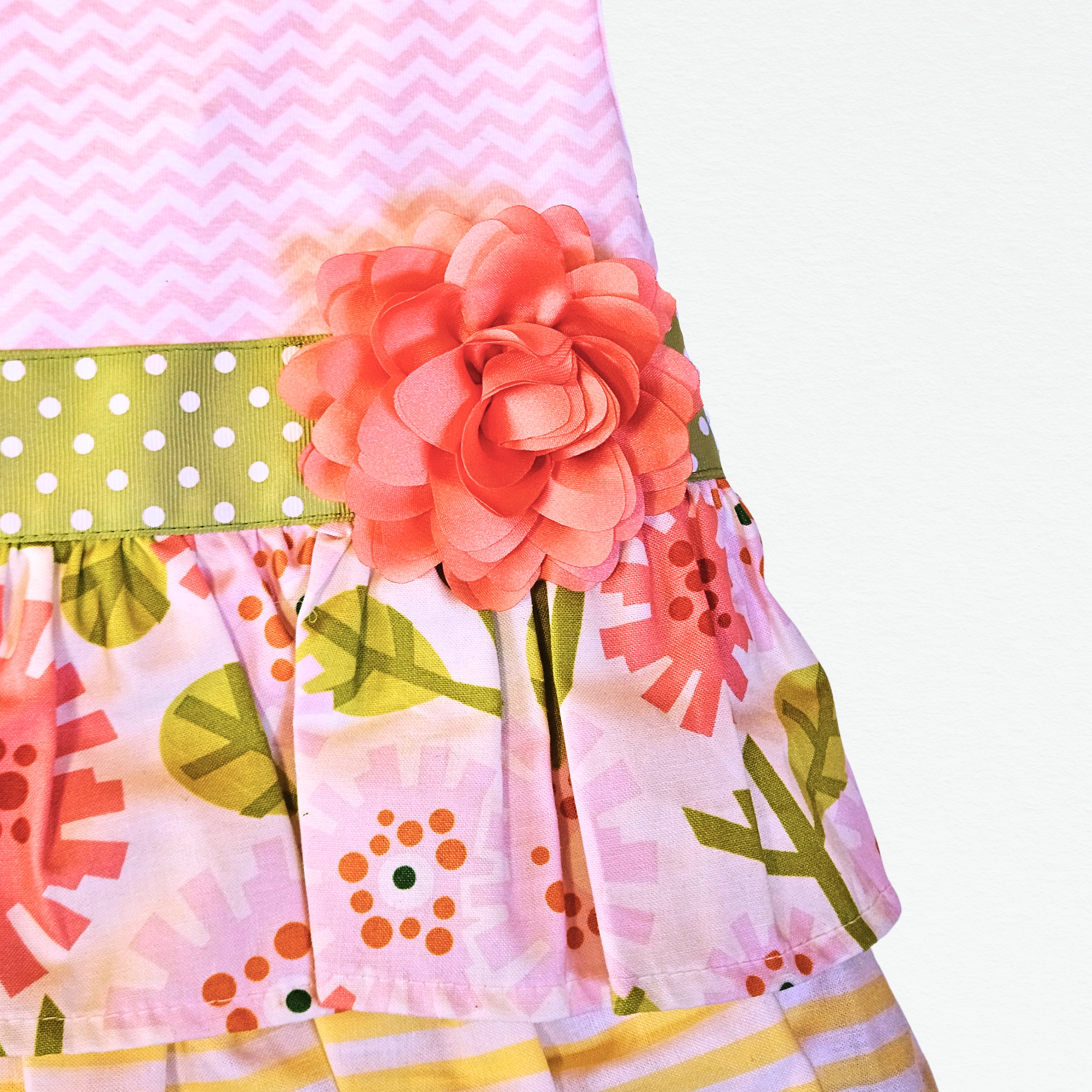 Colorful skirt with floral patterns and a large pink flower accessory on a white background