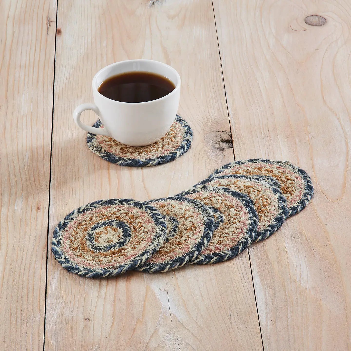 Set of woven coasters with a cup of coffee on a wooden surface