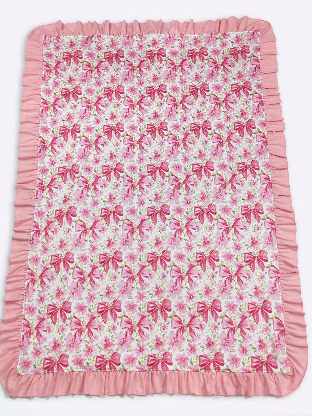 Pink and white blanket with bow pattern on a white background